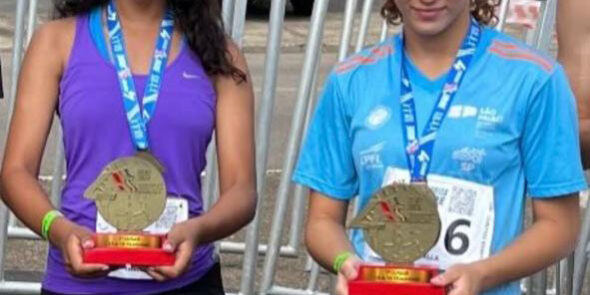 Alunas do vamos pra cima laranja vencem corrida de rua em Sumaré. Duas jovens atletas sorridentes, usando uniformes esportivos, exibem medalhas de ouro e troféus em uma competição.